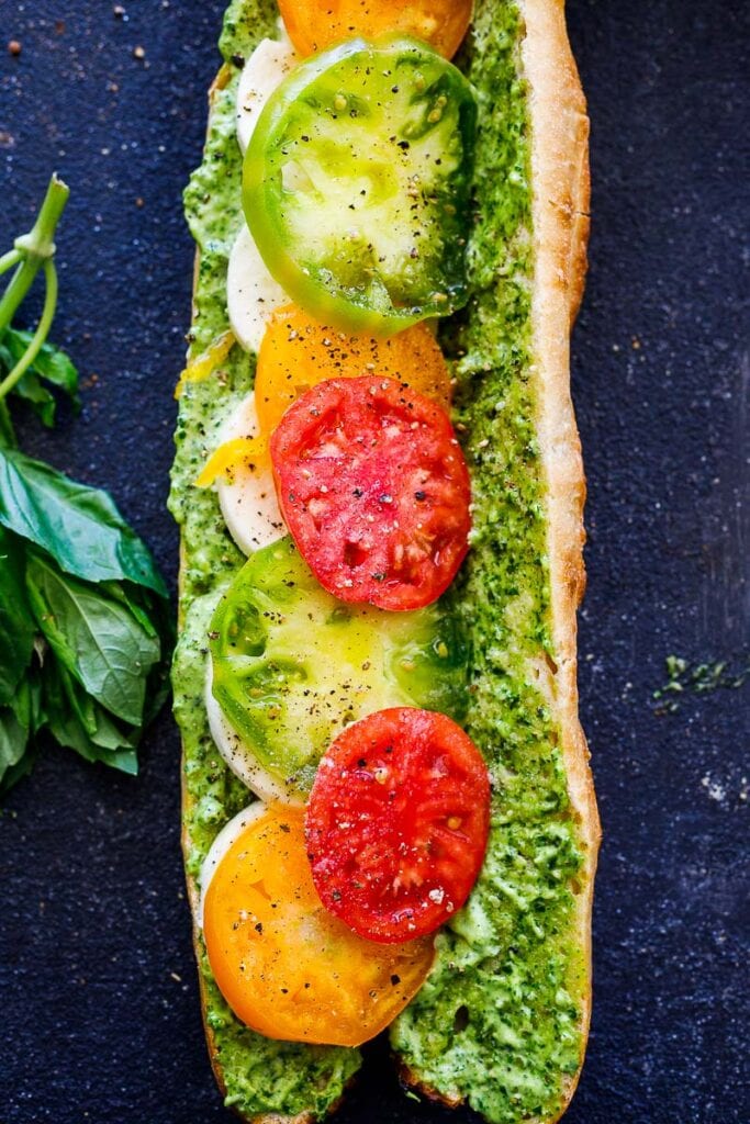 tomato caprese on baguette with pesto, shown open-faced. 