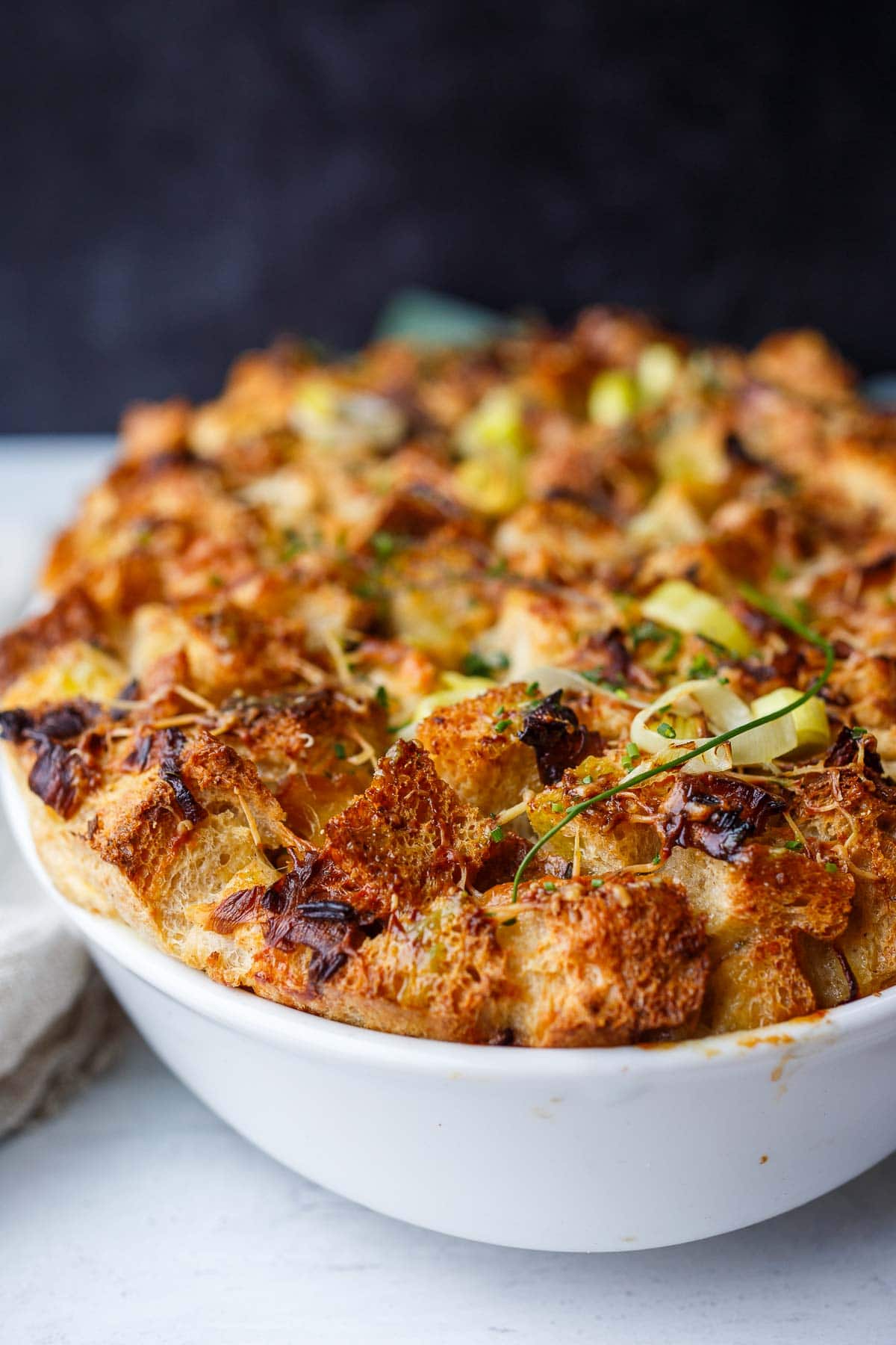 leek bread pudding in a white baking dish. 