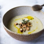 Parsnip Soup with hazelnuts, cardamom and thyme. A simple soup that can be made on the stovetop or roasted in the oven. Vegan Adaptable. #parsnipsoup #parsniprecipes #parsnips