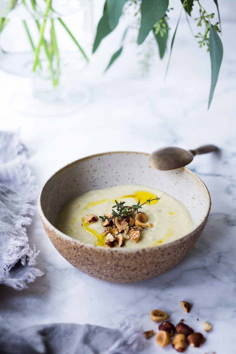 Parsnip Soup with hazelnuts, cardamom and thyme. A simple soup that can be made on the stovetop or roasted in the oven. Vegan Adaptable. #parsnipsoup #parsniprecipes #parsnips 