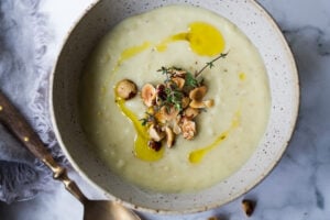Parsnip Soup with hazelnuts, cardamom and thyme. A simple soup that can be made on the stovetop or roasted in the oven. Vegan Adaptable. #parsnipsoup #parsniprecipes #parsnips