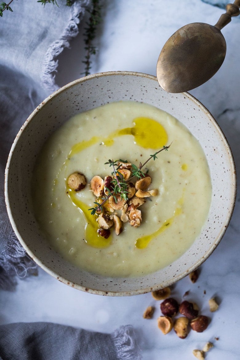 Parsnip Soup with hazelnuts, cardamom and thyme. A simple soup that can be made on the stovetop or roasted in the oven. Vegan Adaptable. #parsnipsoup #parsniprecipes #parsnips