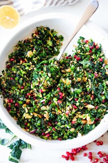 Kale Farro Salad with Almonds and Pomegranate Seeds. Think of this like a Winter Tabbouleh- lemony light and flavorful, this easy Middle Eastern-inspired salad can be made ahead, perfect for mid-week lunches. #healthykalesalad #kalesalad #vegansalad #vegankalesalad #farrosalad #tabouli #tabbouleh