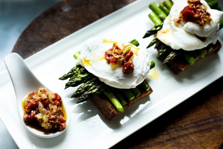 A simple breakfast- Roasted asparagus on toast with poached eggs and a warm bacon vinaigrette. Or make this for dinner! | www.feastingathome.com