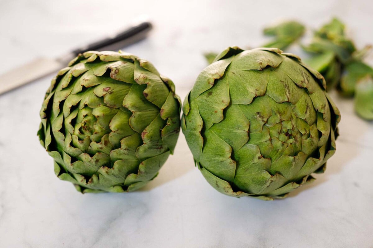 two whole, fresh artichokes.