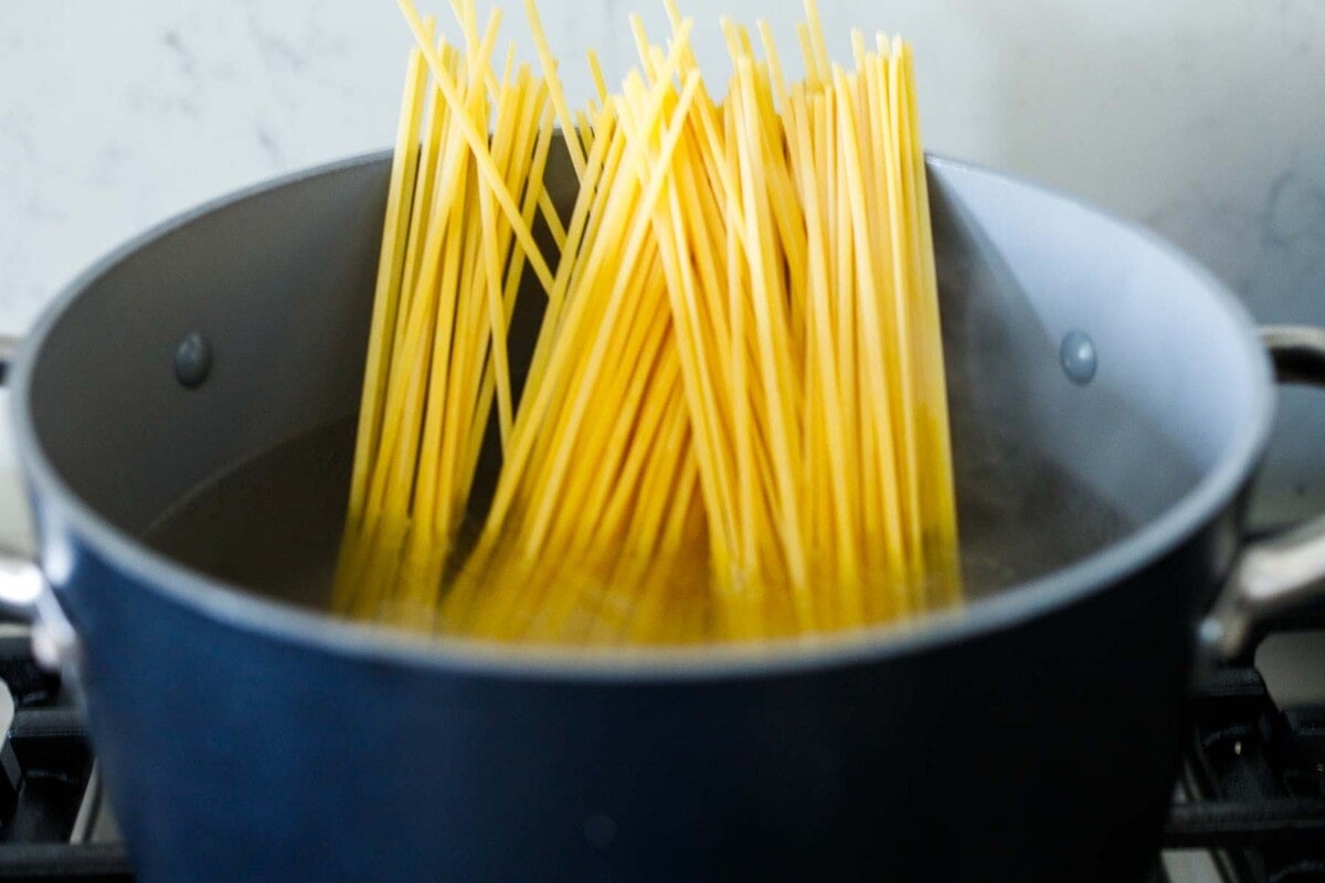 cooking the pasta in a pot. 
