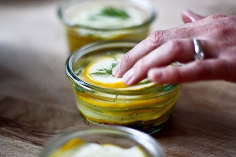 pressing down the zucchini, under the brine.