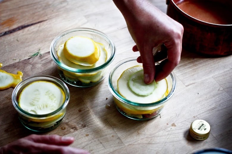 layering the zucchini and summer squash in the jars.