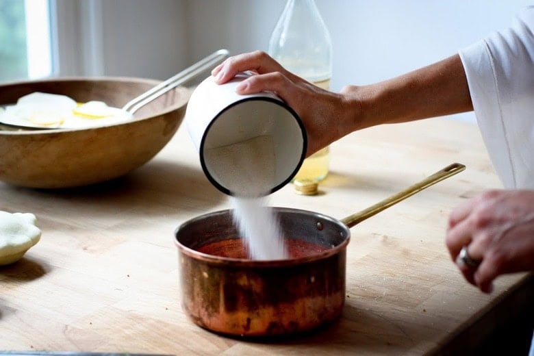 Making the pickle brine- pouring sugar in a saucepan.