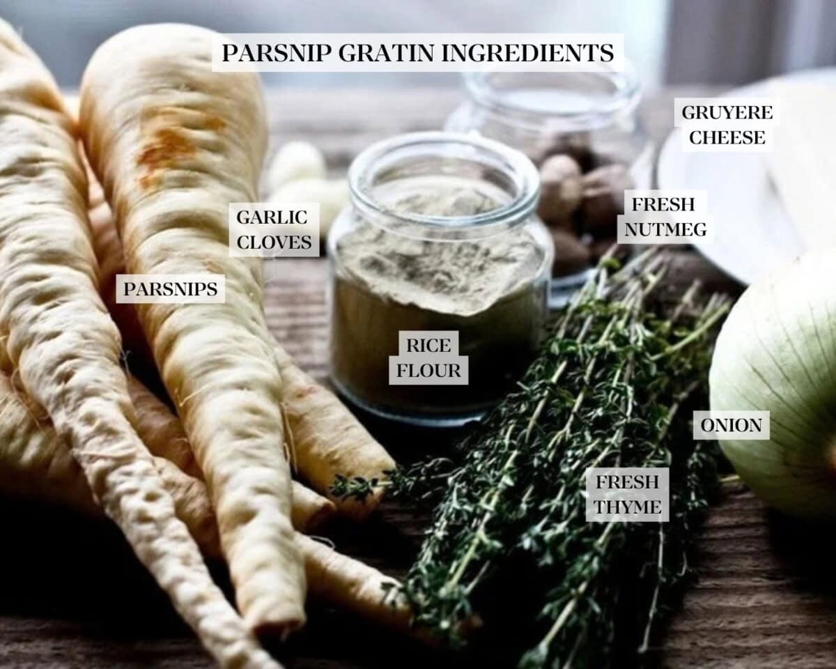 parsnip gratin ingredients laid out on a wood surface and labeled - parsnips, garlic cloves, flour, fresh thyme, onion, fresh nutmeg, and gruyere cheese.