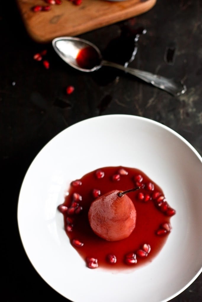 Poached pears get a little makeover with red wine, pomegranate seeds &. cardamom. This easy healthy dessert is perfect after a heavy holiday meal and is a snap to make! #poachedpears