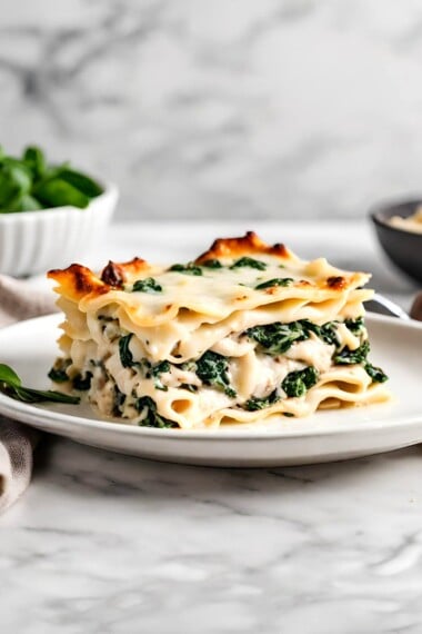 A delicious recipe for creamy Chicken Lasagna with mushrooms, spinach and rosemary layered with a creamy bechamel sauce. Vegetarian-adaptable. See notes for making ahead. 