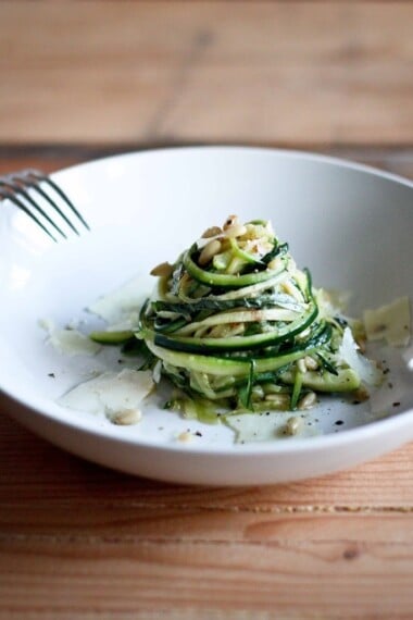 Zucchini Linguine with garlic, olive oil, toasted pine nuts, basil ribbons & shaved pecorino cheese, a simple delicious GF meal,made w/ Zucchini "noodles"! | www.feastingathome.com