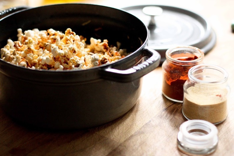 This stove-top recipe for Garlic Parmesan Popcorn is addicting! Sprinkled with smoked paprika, its the perfect snack for movie night. | www.feastingathome.com