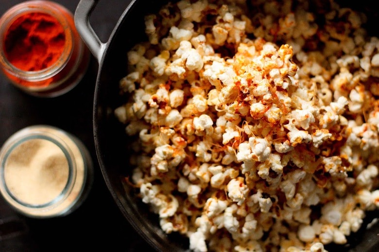 This stove-top recipe for Garlic Parmesan Popcorn is addicting! Sprinkled with smoked paprika, its the perfect snack for movie night. | www.feastingathome.com