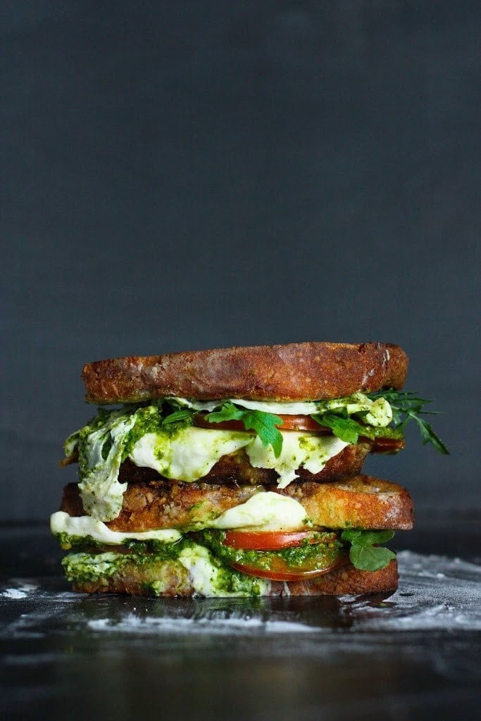 caprese grilled cheese sandwich with greens, tomatoes, and mozzarella - two sandwiches stacked. 