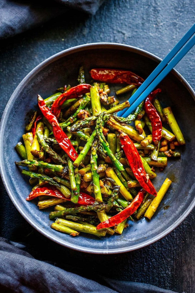 Stir-Fried Asparagus with garlic, ginger, dried chilies and Szechuan sauce - a fast, easy vegan side dish that will spice up your dinner. Serve it with rice and crispy tofu (or chicken), and it becomes a quick and flavorful meal.