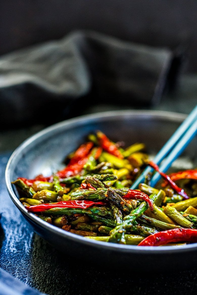 Stir-Fried Asparagus with garlic, ginger, dried chilies and Szechuan sauce - a fast, easy vegan side dish that will spice up your dinner. Serve it with rice and crispy tofu (or chicken), and it becomes a quick and flavorful meal.