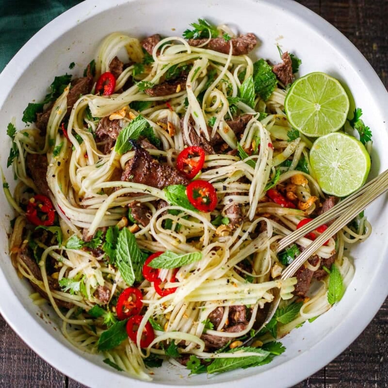 This Vietnamese Green Papaya Salad is topped with tender grilled lemongrass beef, fresh herbs, and tangy Nuoc Cham dressing for a fresh, flavorful, protein-packed meal. 