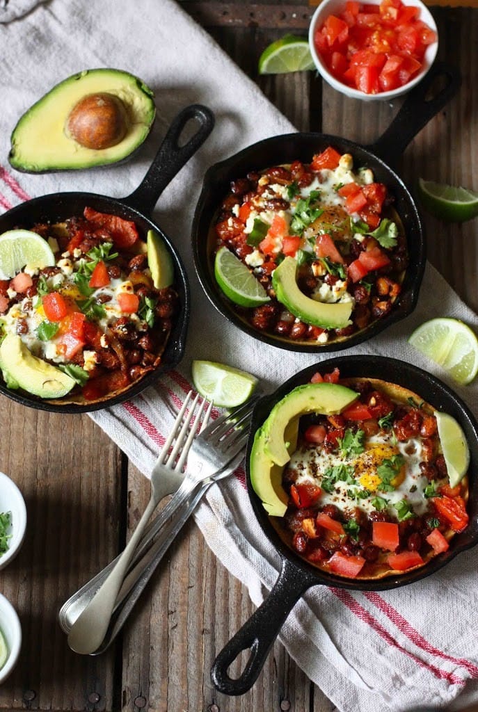 Skillet Huevos Rancheros - a healthy vegetarian version of one of our favorite Mexican-style breakfasts! Eggs are baked over flavorful beans with crispy tortillas, then topped with avocado, fresh tomato and cilantro...a simple healthy vegetarian brunch recipe!