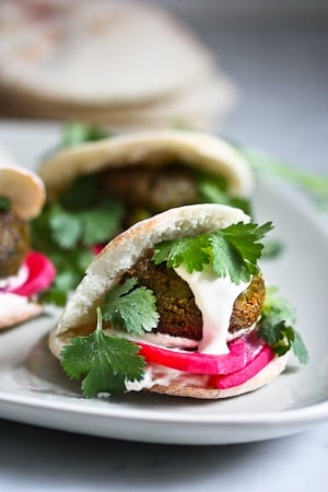 Falafels with Tahini Sauce. This authentic recipe is made with soaked, uncooked chickpeas and hands-down has the BEST texture and flavor! So easy! Bake them or pan-sear them. Great in wraps, bowls, or salads. |  #falafel #falafels #falafelrecipe #falafelsalad, #bowl #veganfalafelrecipe #bakedfalafel #vegan #easyfalafel