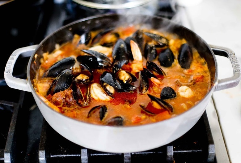 Summer Seafood Stew in a light and flavorful tomato-fennel broth with smoky chorizo. Serve with Crusty Bread to mop up all the flavorful juices! #bouillabaisse #fishstew #seafoodstew #stew #cioppino #seafood #fish #fishsoup #seafoodsoup 