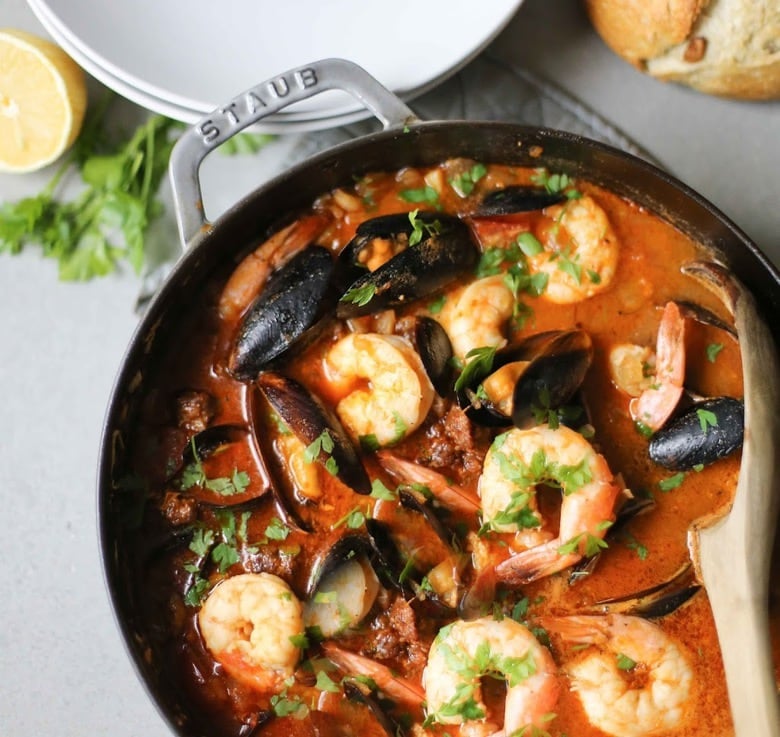 Summer Seafood Stew in a light and flavorful tomato-fennel broth with smoky chorizo. Serve with Crusty Bread to mop up all the flavorful juices! #bouillabaisse #fishstew #seafoodstew #stew #cioppino #seafood #fish #fishsoup #seafoodsoup 