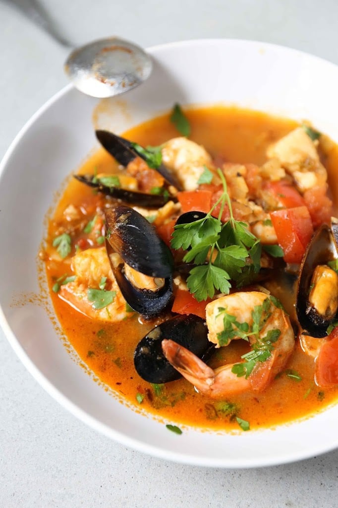 Summer Seafood Stew in a light and flavorful tomato-fennel broth with smoky chorizo. Serve with Crusty Bread to mop up all the flavorful juices! #bouillabaisse #fishstew #seafoodstew #stew #cioppino #seafood #fish #fishsoup #seafoodsoup 