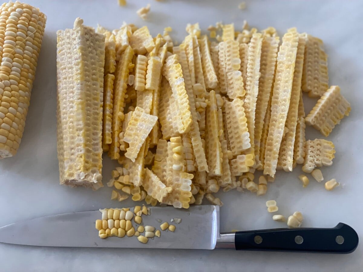 cutting corn kernels off the cob.