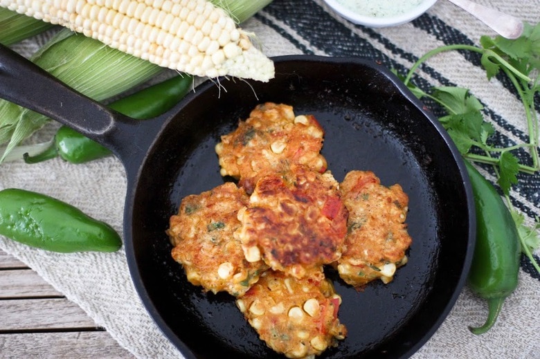 Spicy Corn Fritters with Cilantro Cream - an easy delicious recipe that works as an appetizer or vegetarian main! www.feastingathome.com #cornfritters #corncakes 