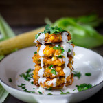 Spicy Corn Fritters with Cilantro Cream - an easy delicious recipe that works as an appetizer or vegetarian main! www.feastingathome.com #cornfritters #corncakes