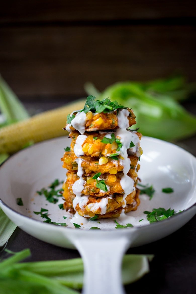 Spicy Corn Fritters with Cilantro Cream - an easy delicious recipe that works as an appetizer or vegetarian main! www.feastingathome.com #cornfritters #corncakes