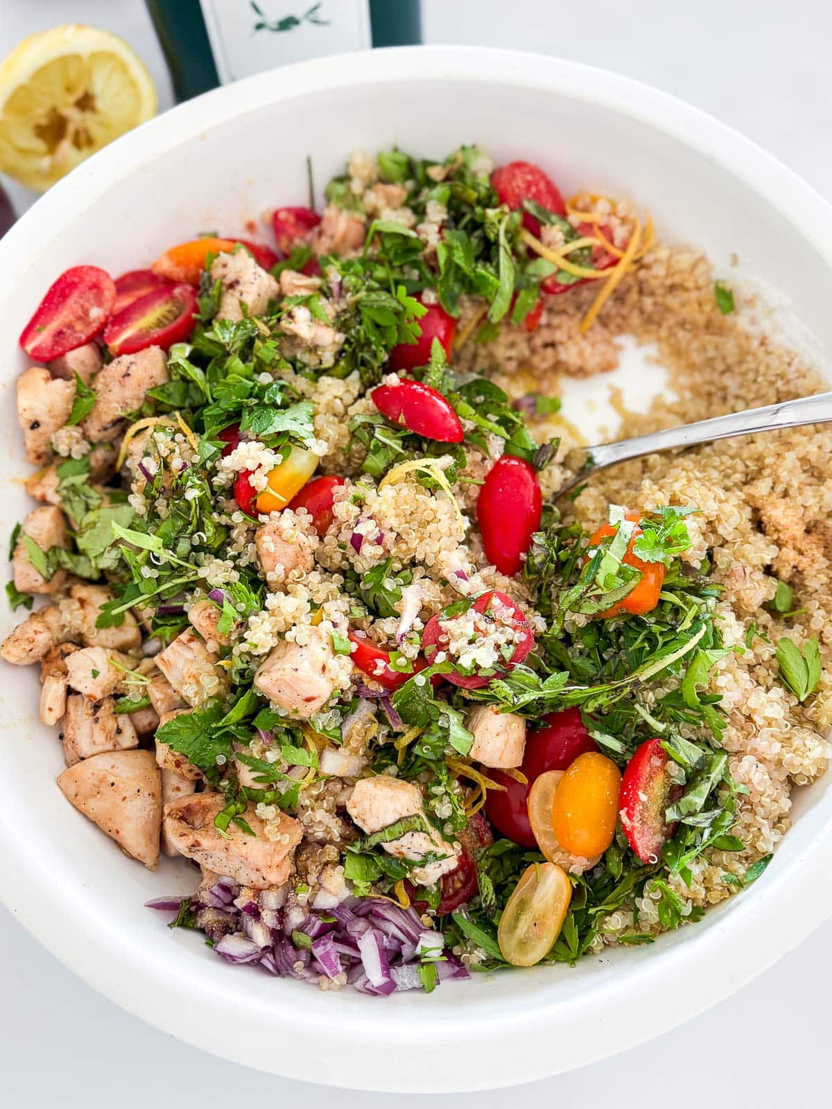 Tossing the quinoa salad with the dressing ingredients.