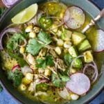 A delicious recipe for Pozole Verde- a flavorful Mexican stew made with tomatillos, green chilies, chicken and hominy, topped with cilantro, avocado and red onions. #pozole