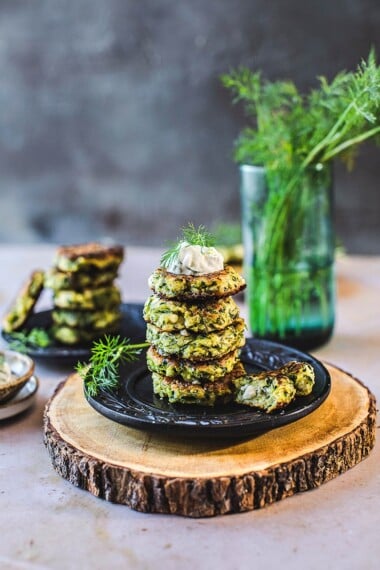 Zucchini Fritters with dill, feta and Tzatziki Sauce, a simple easy way to use up summer squash and zucchini! Healthy and light! #zucchinifritters #zucchinicakes #zucchinirecipes