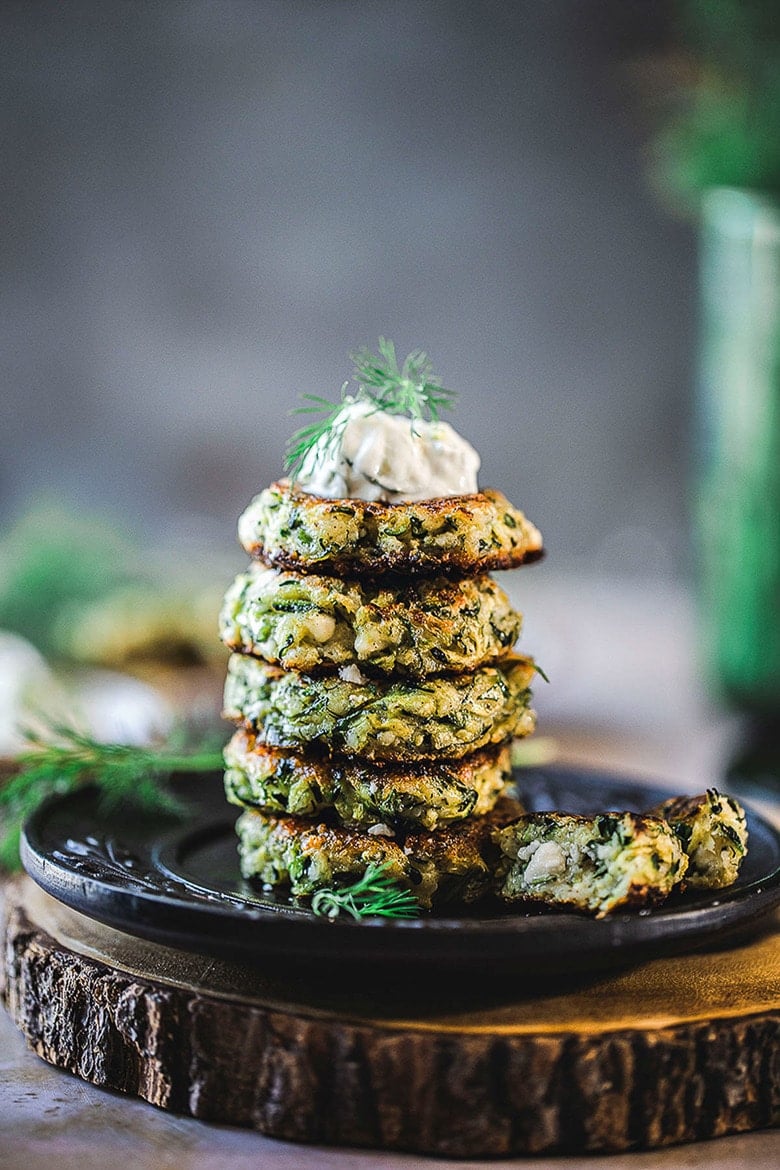 Zucchini Fritters with dill, feta and Tzatziki Sauce, a simple easy way to use up summer squash and zucchini! Healthy and light! #zucchinifritters #zucchinicakes #zucchinirecipes