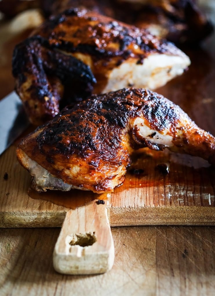 Finished Portuguese Chicken with Crispy skin cut up on a cutting board.