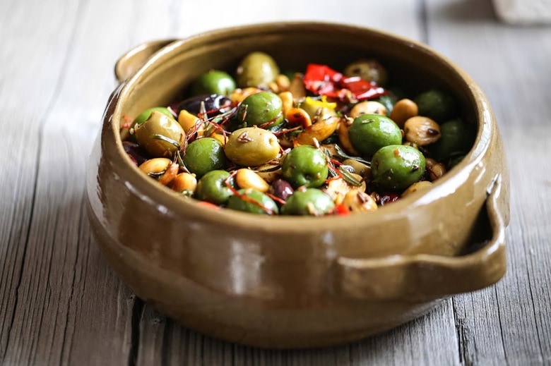 Warm olives with rosemary, garlic, and almonds - a simple, delicious appetizer that is full of amazing flavor, that can be made very quickly and easily! #warmolives #olives #marcona #almonds #rosemaryolives
