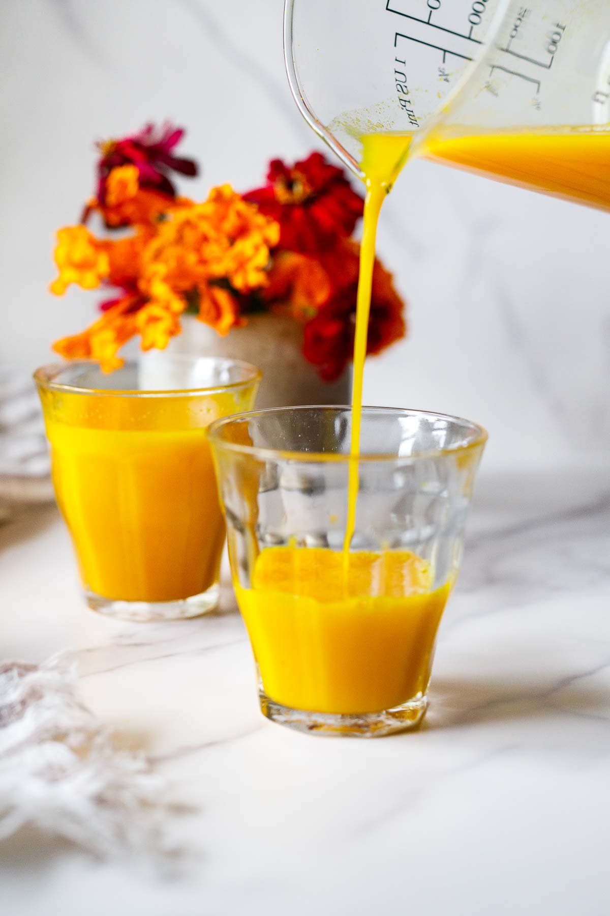 Delicious and immune-boosting, this ginger turmeric shot recipe is made with fresh turmeric root, ginger, orange, lemon, and black pepper.
