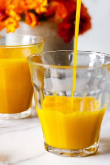 Tumeric Ginger shot being poured into a glass.