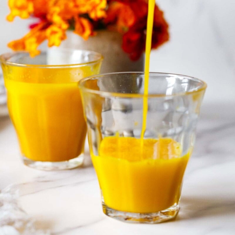 Tumeric Ginger shot being poured into a glass.