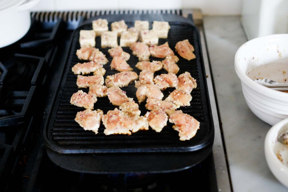grilling tofu and chicken in lemongrass marinade on stovetop cast iron grill pan.