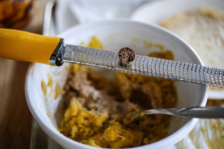 Savory Mushroom Crepes with Spaghetti Squash and Sage drizzled with Bechemal Sauce - a hearty cozy vegetarian dinner recipe, perfect for the colder months! #crepes #savorycrepes #mushroomcrepes #mushroomcrepes www.feastingathome.com