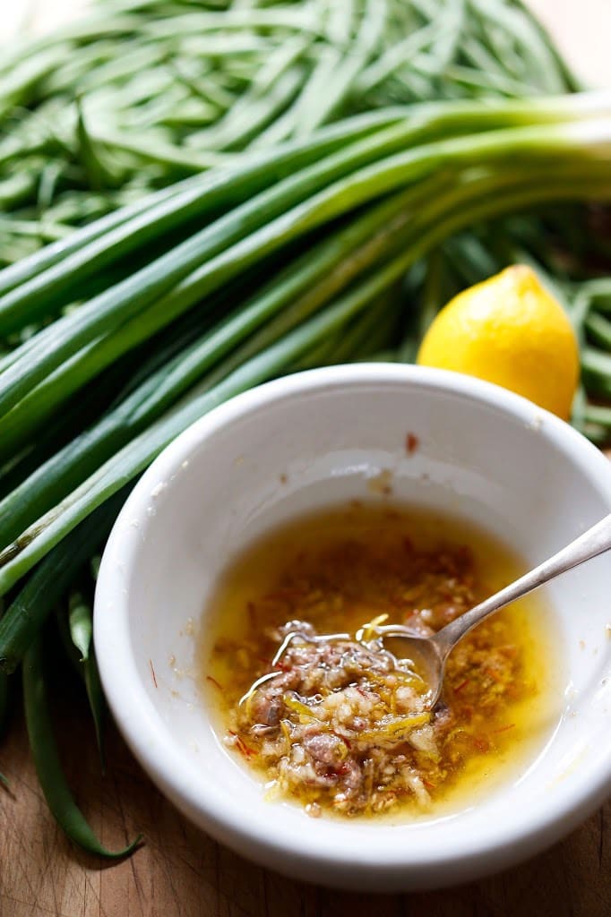 Bagna Cauda- Charred Green Beans with Bagna Cauda- an Itailian Marinade with olive oil, anchovies, garlic and chili flakes. Roasted in the oven with scallions and lemon zest, these green beans are full of umami flavor. | www.feastingathome.com 