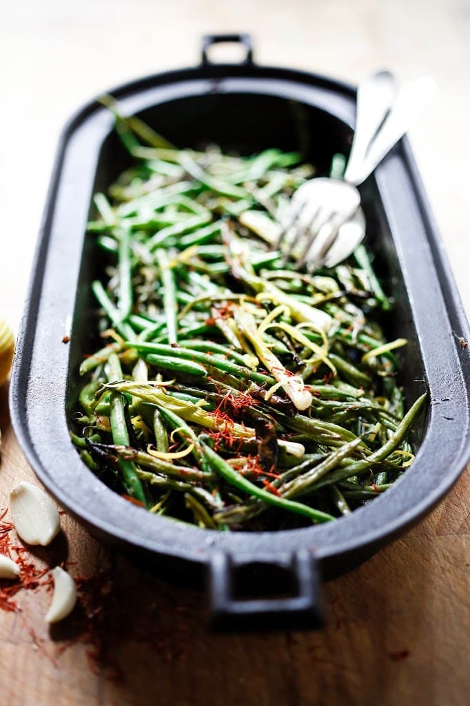 Charred Green Beans with Bagna Cauda- an Itailian Marinade with olive oil, anchovies, garlic and chili flakes. Roasted in the oven with scallions and lemon zest, these green beans are full of umami flavor. | www.feastingathome.com