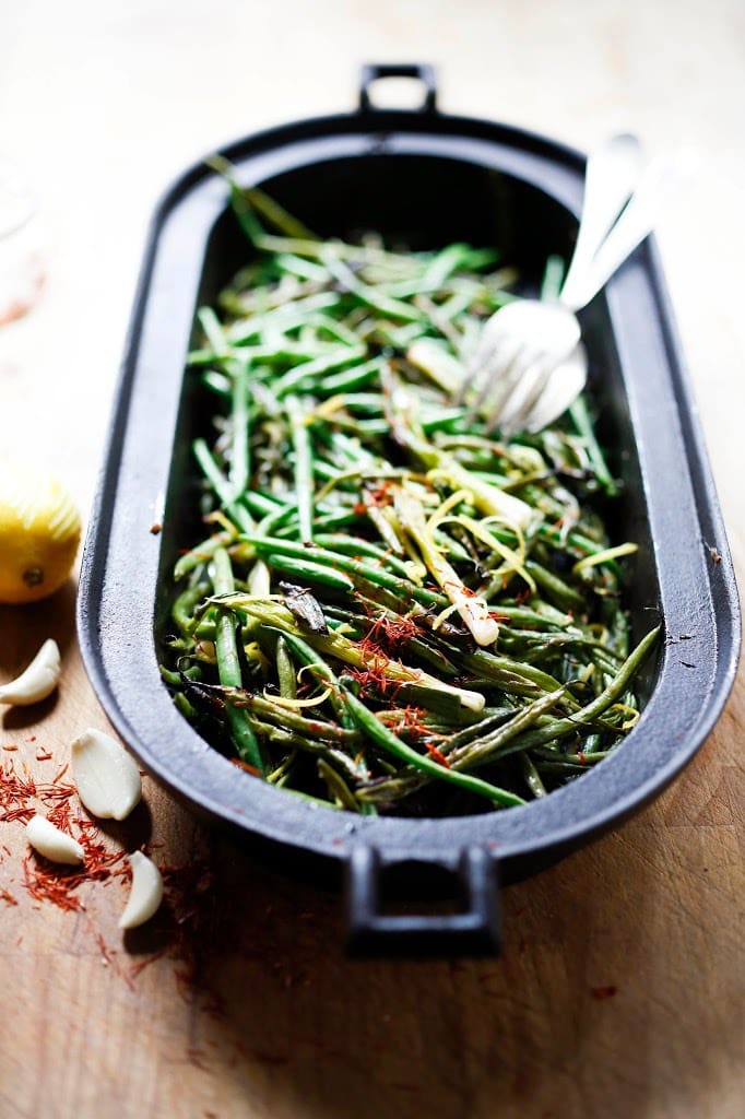 Roasted Green Beans with Bagna Cauda- an Itailian Marinade with olive oil, anchovies, garlic and chili flakes. Roasted in the oven with scallions and lemon zest, these green beans are full of umami flavor. | www.feastingathome.com 