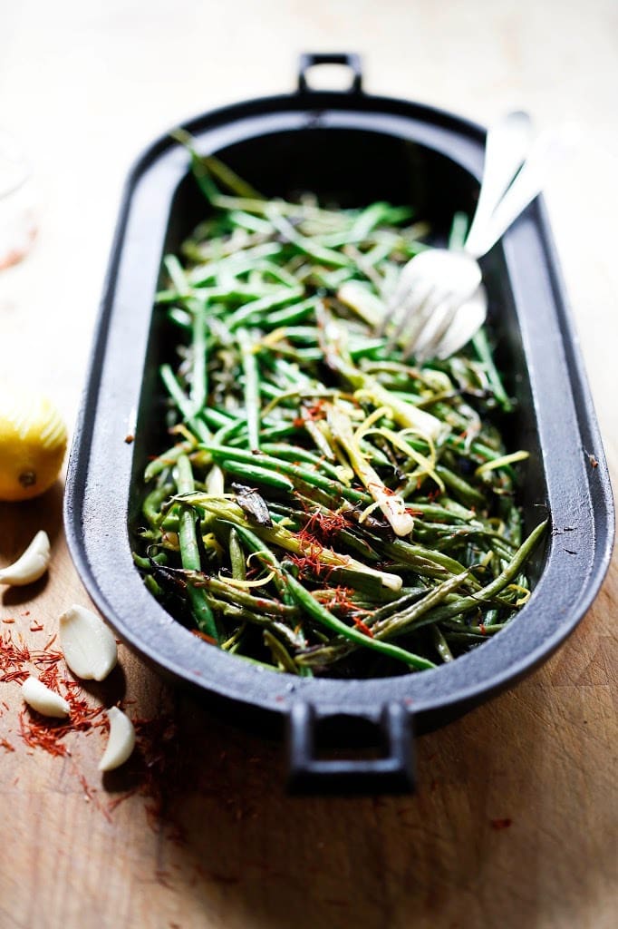 Roasted Green Beans with Bagna Cauda- an Itailian Marinade with olive oil, anchovies, garlic and chili flakes. Roasted in the oven with scallions and lemon zest, these green beans are full of umami flavor. | www.feastingathome.com