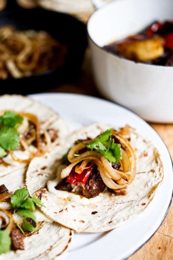 Tender, falling off the bone braised beef are the star of these Mexican short rib tacos, cooked low and slow in the oven with dried Mexican chilies, beef stock and stout. | www.feastingathome.com