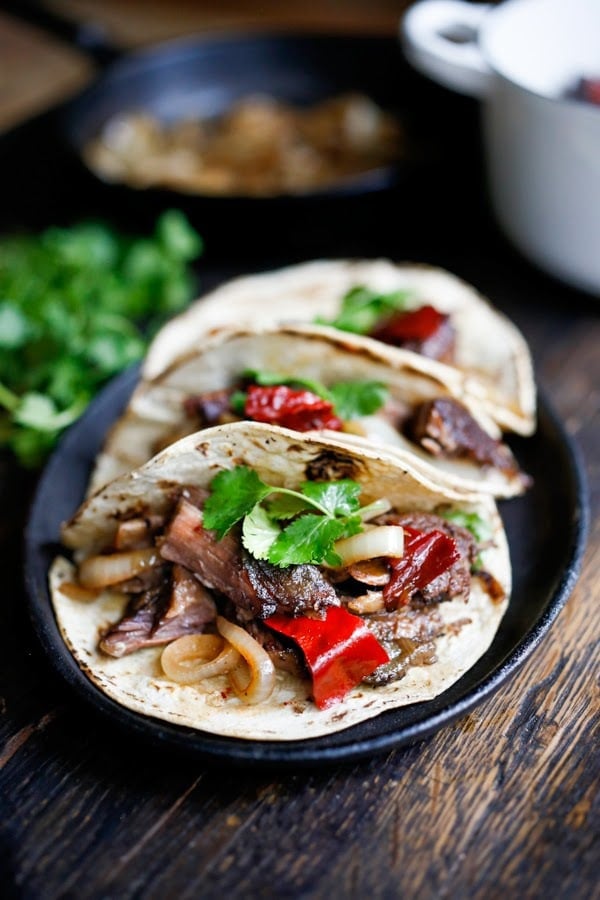 Tender, falling off the bone braised beef are the star of these Mexican short rib tacos, cooked low and slow in the oven with dried Mexican chilies, beef stock and stout. | www.feastingathome.com