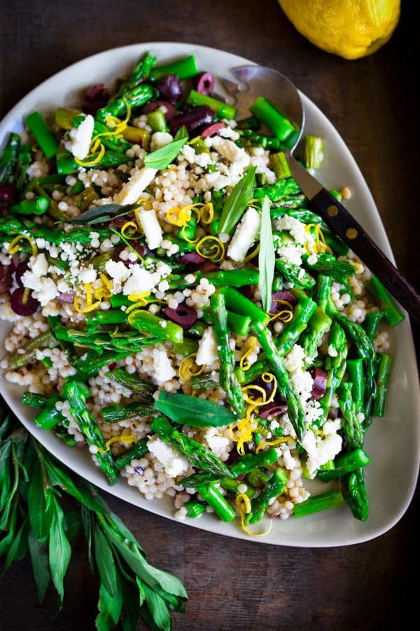 A delicious recipe for Spring Asparagus Salad with Cous Cous, kalamata olives, lemon zest and Mint in a zesty lemony dressing.| www.feastingathome.com 